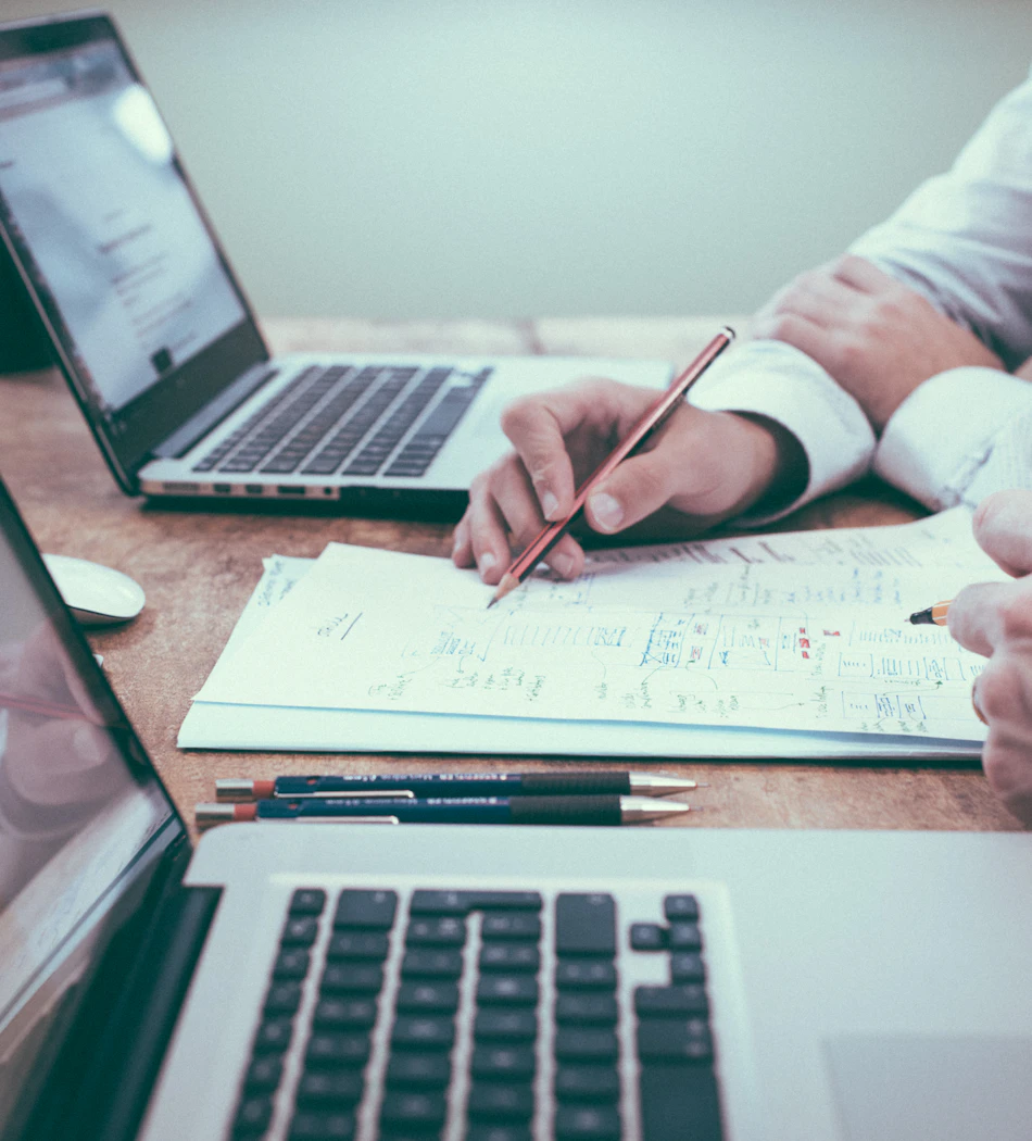 Working together over documents and laptops at a desk