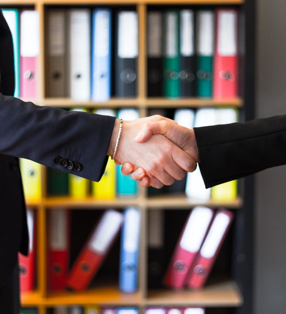 A confident handshake between advisor and client in an office